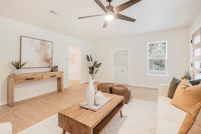 Living room with ceiling fan and light wood-style floors | Image 7