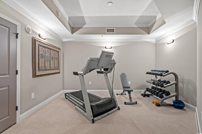 Exercise area featuring a tray ceiling, crown molding, and carpet floors | Image 28