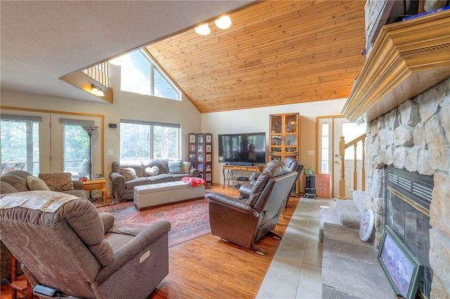 Living area featuring a fireplace, high vaulted ceiling, french doors, and light wood finished floors | Image 6