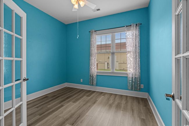 Spare room featuring wood finished floors, a ceiling fan, and french doors | Image 28