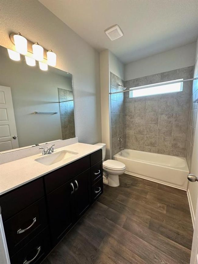 Full bathroom with wood finished floors, toilet, bathtub / shower combination, and vanity | Image 13