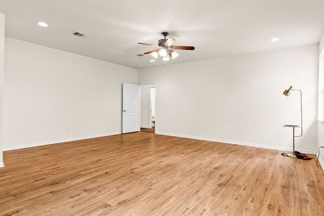 Spare room featuring light wood finished floors, ceiling fan, visible vents, and recessed lighting | Image 24