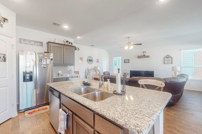 Kitchen featuring plenty of natural light, a sink, visible vents, and stainless steel appliances | Image 7