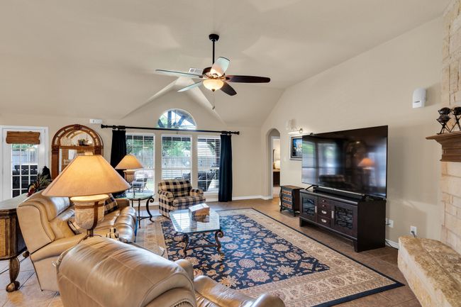 Living room featuring tall ceilings, electric fireplace, and tons of natural light | Image 13