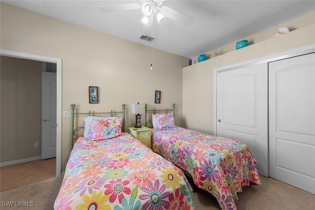 Carpeted bedroom with a ceiling fan, visible vents, and a closet | Image 22