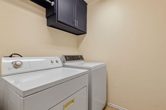 The utility room has built in cabinets and hanging rod. Washer and dryer can stay. | Image 21