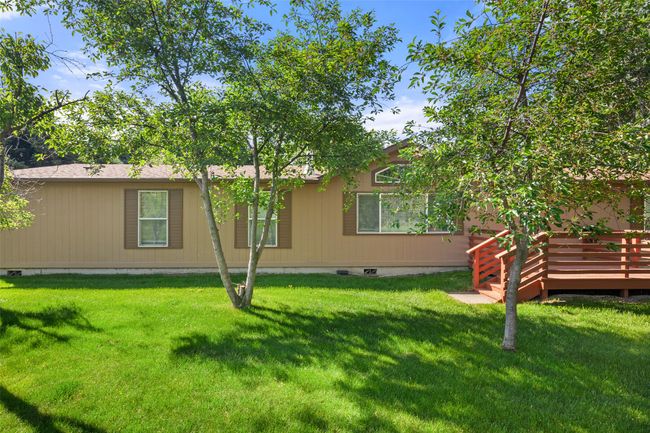 Rear view of property featuring a deck, a lawn, and crawl space | Image 31