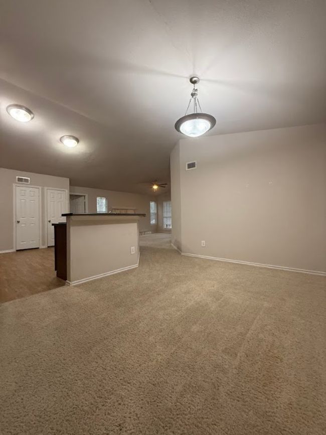 Unfurnished living room featuring carpet floors and baseboards | Image 11