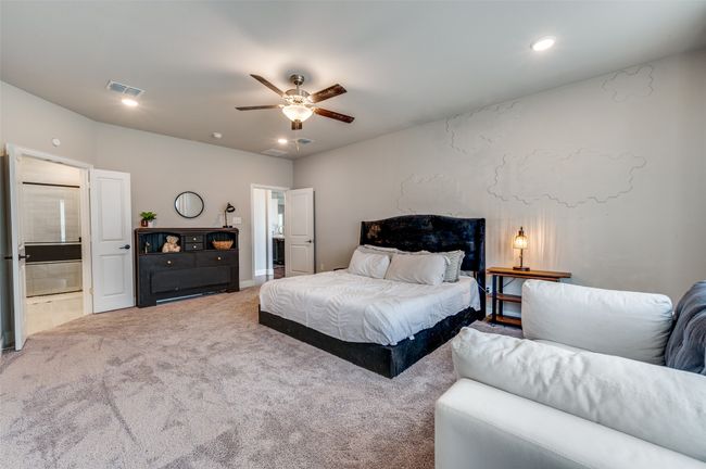 Carpeted bedroom with visible vents, ceiling fan, recessed lighting, and ensuite bathroom | Image 28