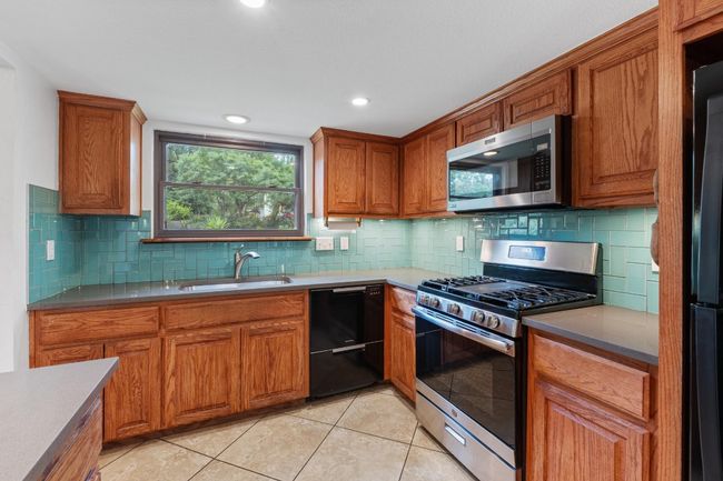 The kitchen’s open layout keeps you connected to the action, with direct line views out to the incredible backyard | Image 10