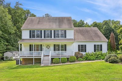 Colonial house with a storage unit, a porch, and a front lawn | Image 1