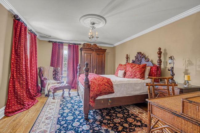 Bedroom featuring crown molding, wood-type flooring, and a notable chandelier | Image 18