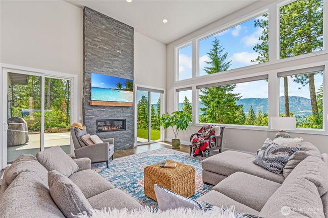 Gather in the spacious living room, where a stunning floor-to-ceiling fireplace wall serves as the focal point | Image 13