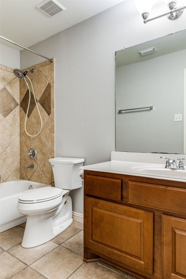 Bathroom with vanity, tub / shower combination, and tile patterned floors | Image 22