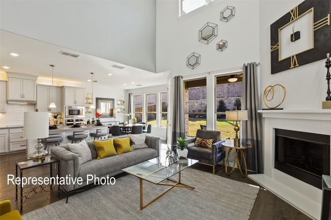 Living room with a fireplace with raised hearth, visible vents, dark wood-style floors, and a high ceiling | Image 5