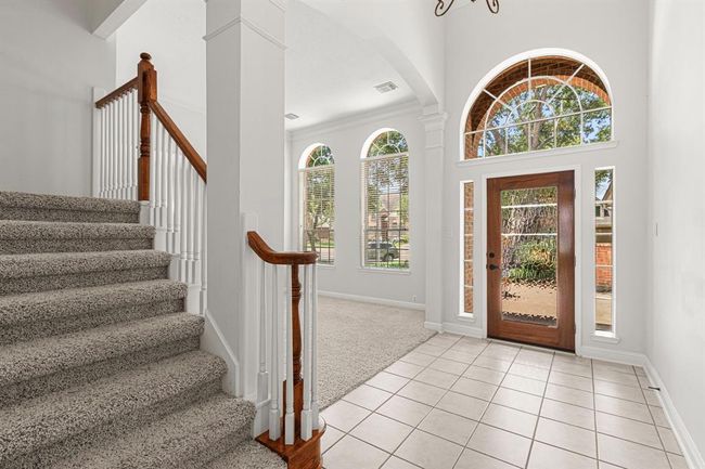 Front door has arched window above it, matched by double arched windows in formal living room. | Image 4