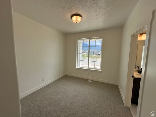 Empty room with a textured ceiling and light carpet | Image 22