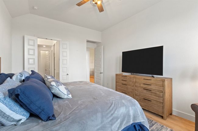 Bedroom featuring light wood-style flooring, vaulted ceiling, and a ceiling fan | Image 6