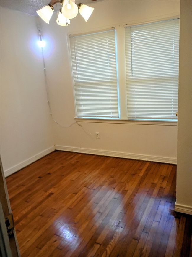 Empty room featuring hardwood / wood-style flooring, baseboards, and a chandelier | Image 4