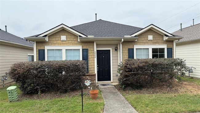 Charming single-story home with a neat front yard, featuring a black door, shutters, and decorative siding. It has a cozy, welcoming appearance with well-maintained landscaping. | Image 11