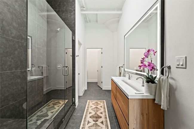 Bathroom with a stall shower, tile patterned flooring, and vanity | Image 27