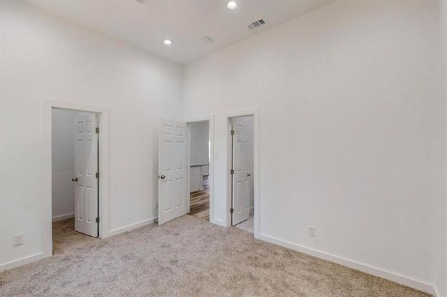 Unfurnished bedroom with a towering ceiling and light carpet | Image 20