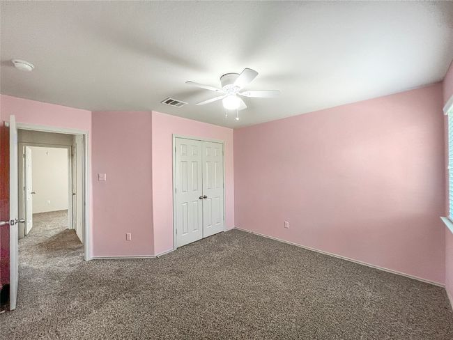 Unfurnished bedroom with dark carpet, a closet, and ceiling fan | Image 18