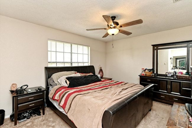 Primary Bedroom featuring light carpet, ceiling fan, and a textured ceiling | Image 13