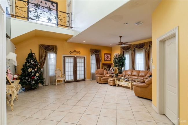 Tiled living room featuring french doors and ceiling fan | Image 9