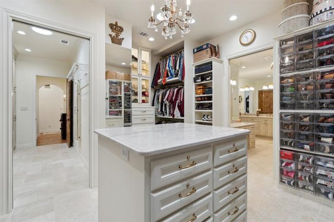 The attractive and large center islandis capped with leathered Taj Mahal quartzite and yields an amazing amount of additional storage. A private entrance to the laundry room adds yet another convenience. | Image 27