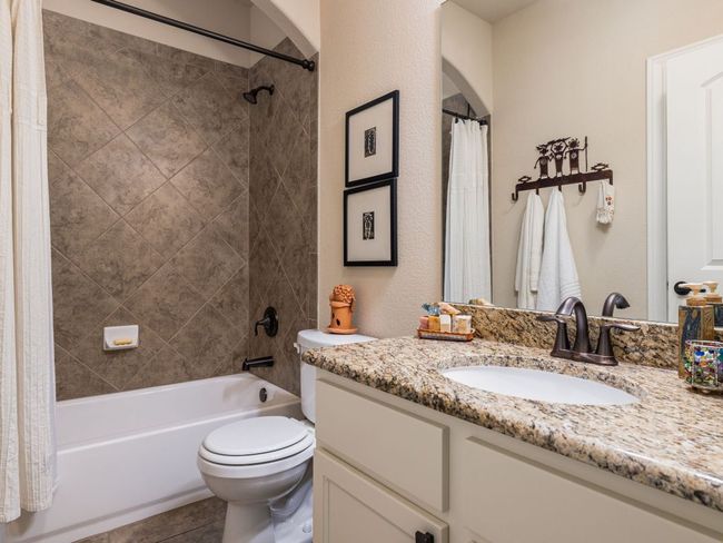 Full bathroom with vanity, shower / bath combination with curtain, a textured wall, and tile patterned flooring | Image 21