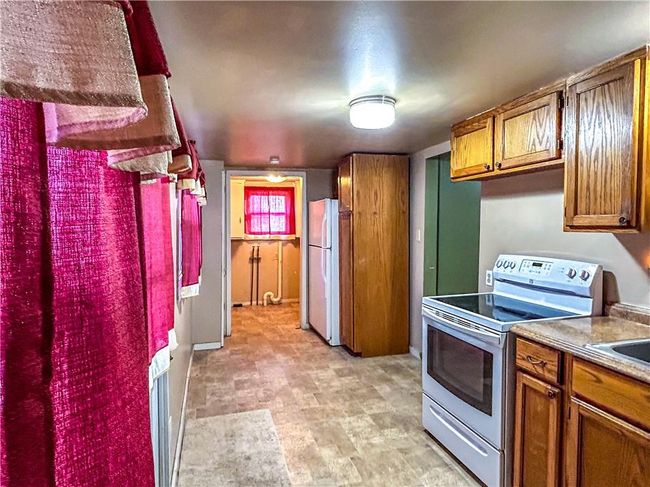 Kitchen with white appliances and brown cabinetry | Image 19