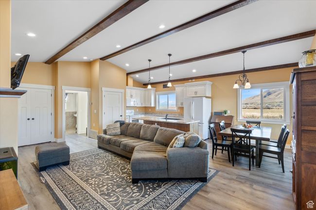 Living area featuring vaulted ceiling with beams, recessed lighting, light wood-type flooring, and baseboards | Image 8