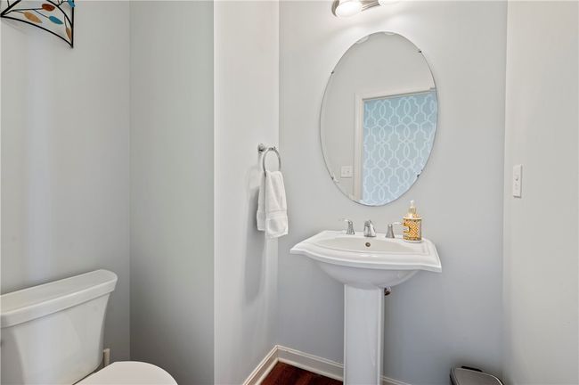The half bath includes hardwood floors and a pedestal sink. | Image 13