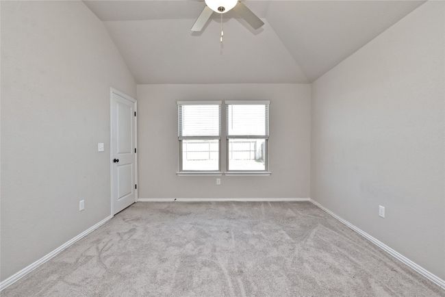 Empty room featuring baseboards, carpet floors, a ceiling fan, and vaulted ceiling | Image 16