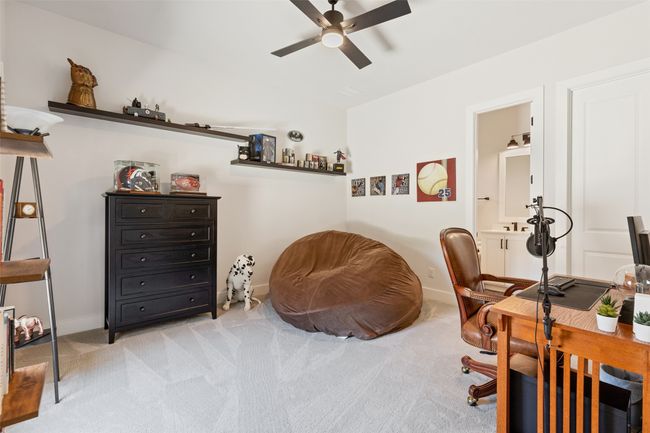 Home office with light carpet, baseboards, a ceiling fan, and vaulted ceiling | Image 23