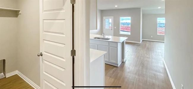 Hallway with wood finished floors, plenty of natural light, baseboards, and a sink | Image 9