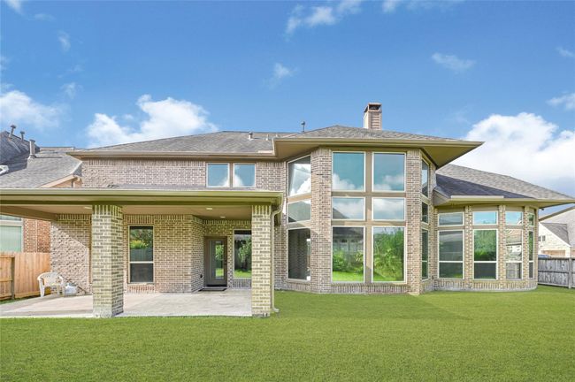 The spacious covered patio offers a comfortable outdoor retreat, perfectly positioned for weekend barbecues or quiet evenings looking out toward the open yard. | Image 41