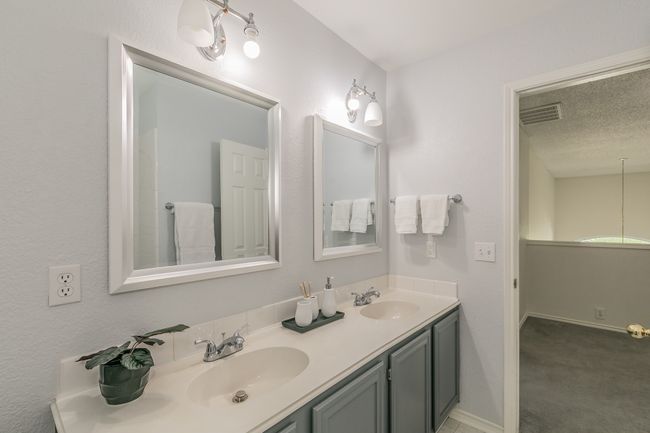 Bathroom featuring baseboards, visible vents, a sink, and double vanity | Image 23