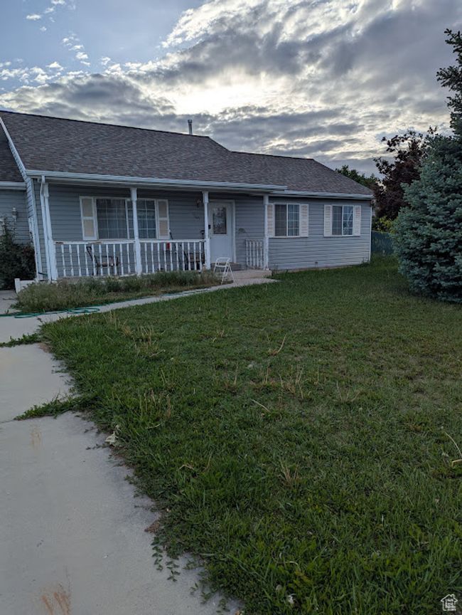 Ranch-style house with covered porch, a front yard, and a shingled roof | Image 24