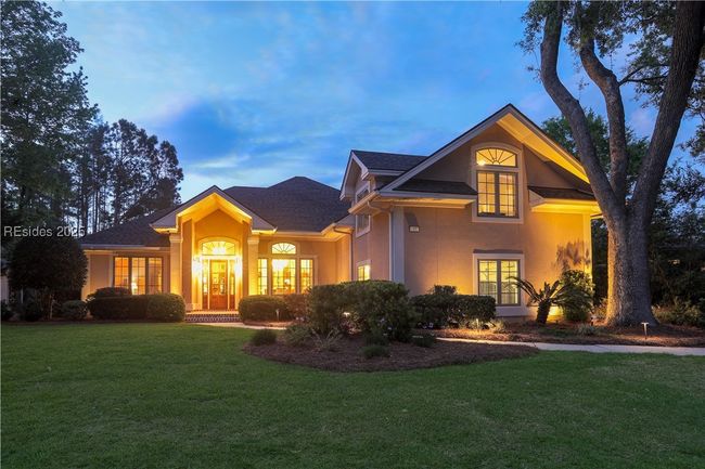 Gorgeous timer-controlled lighting on the home in the evening exudes the beauty of the exterior and lush landscaping. | Image 4