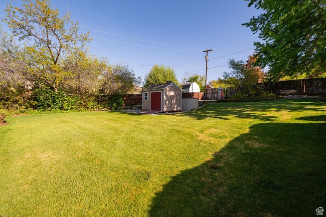 View of yard with an outdoor structure, a fenced backyard, and a shed | Image 7
