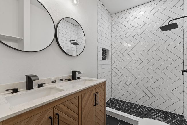 Bathroom featuring double vanity and a tile shower | Image 13