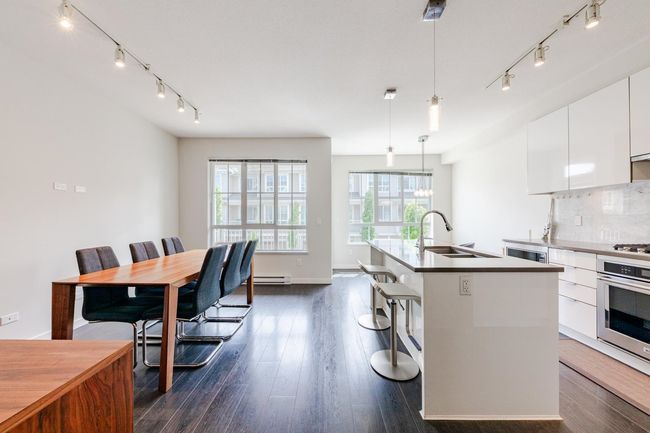 Kitchen featuring appliances with stainless steel finishes, rail lighting, white cabinets, modern cabinets, and a kitchen island with sink | Image 5