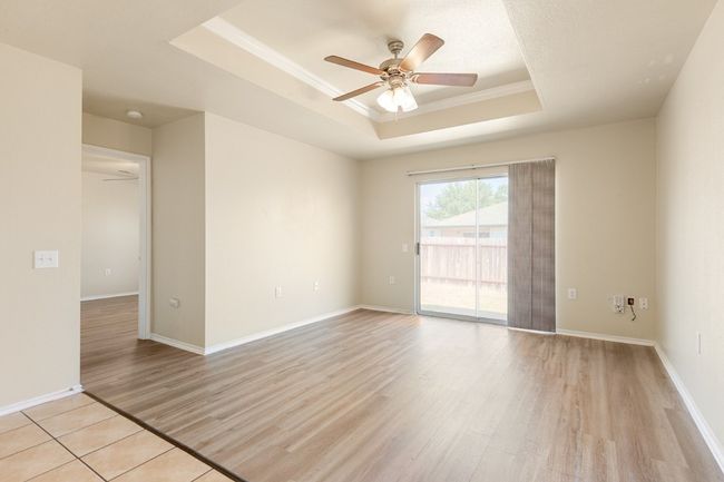 Unfurnished room with a tray ceiling, light wood-style floors, a ceiling fan, and ornamental molding | Image 15
