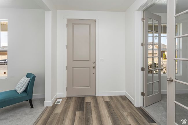 Foyer entrance with baseboards, visible vents, wood finished floors, and french doors | Image 39