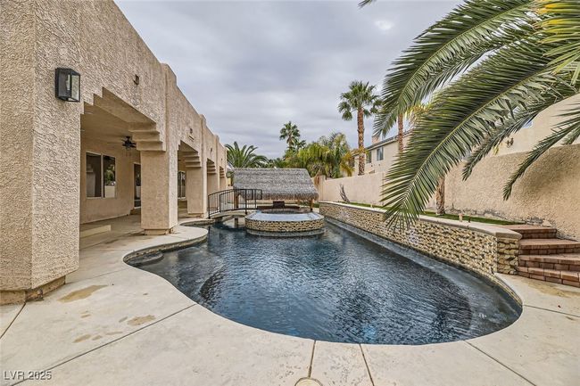 View of swimming pool with a fenced backyard, a patio area, a pool with connected hot tub, and a ceiling fan | Image 42