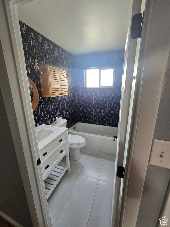 Full bath featuring a bathtub, vanity, tile patterned floors, and tile walls | Image 6