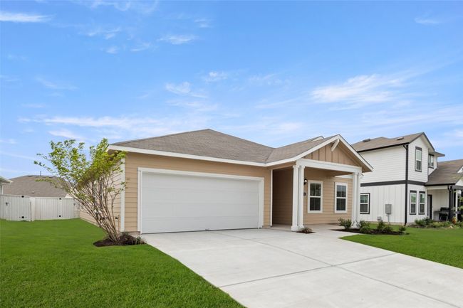 Single story home with board and batten siding, a front yard, an attached garage, and concrete driveway | Image 24