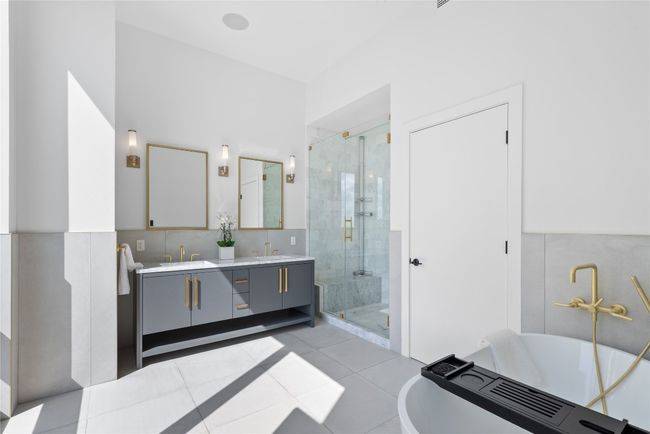 Bathroom featuring double vanity, a stall shower, a freestanding bath, and tile patterned floors | Image 19